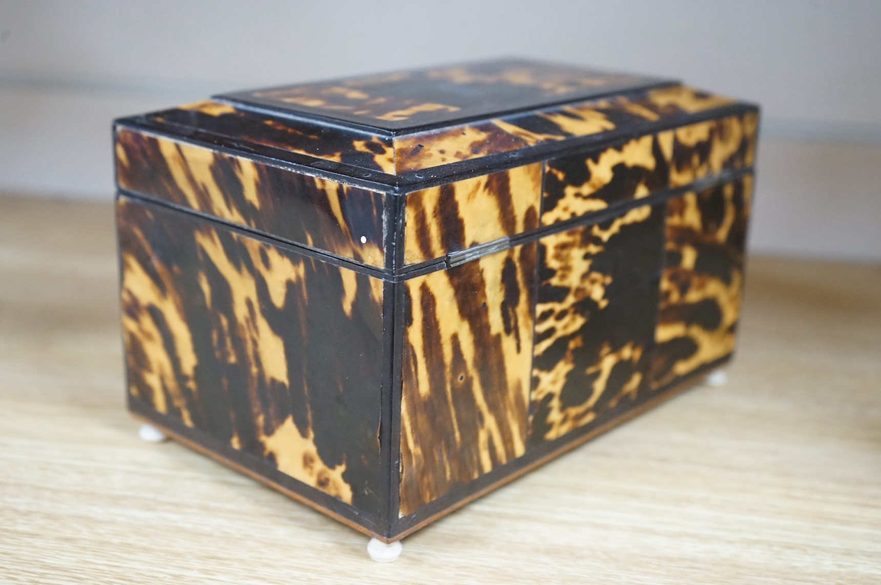 A 19th century tortoiseshell serpentine jewellery box with ivory ball feet and key, 20cm wide. Condition - some damage to tortoiseshell. CITES Submission reference, QRKRAJGK